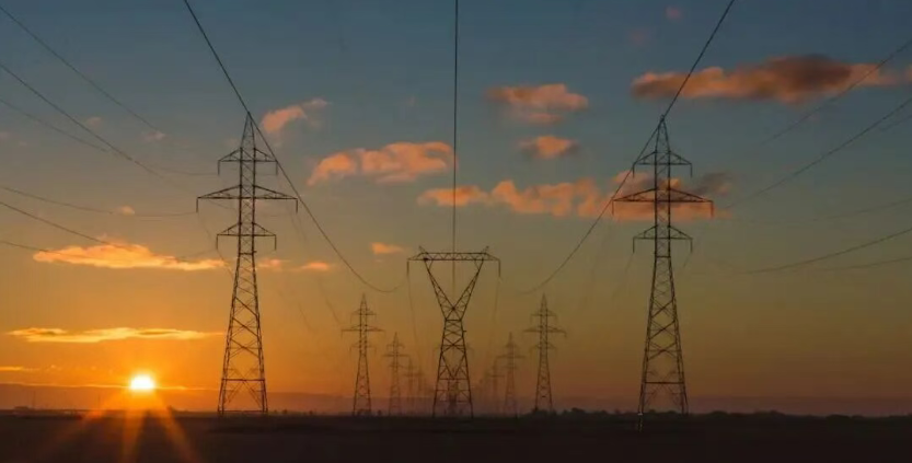 High-voltage transmission lines at sunset