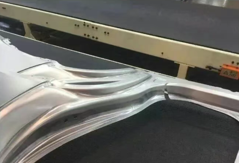 Stamped aluminum automotive panel on conveyor