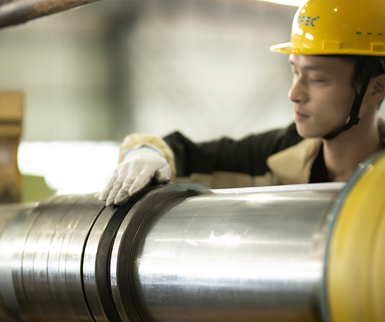 Worker inspecting steel coil