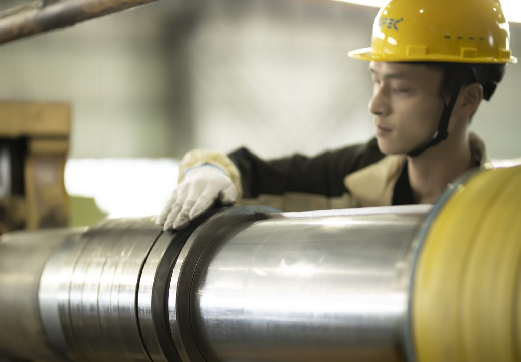 Worker inspecting steel coil